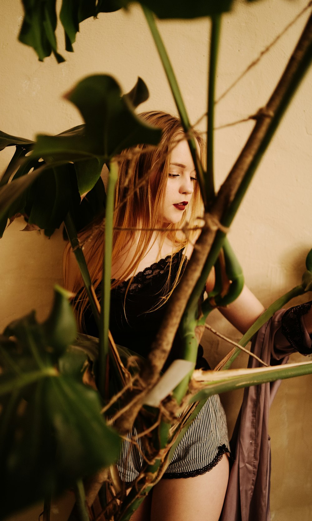 woman in black shirt holding green plant