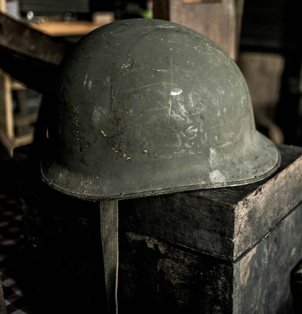 grauer Helm auf braunem Holztisch