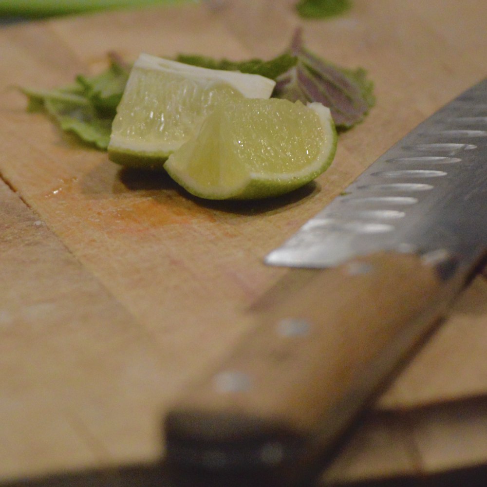 sliced green fruit on brown wooden chopping board