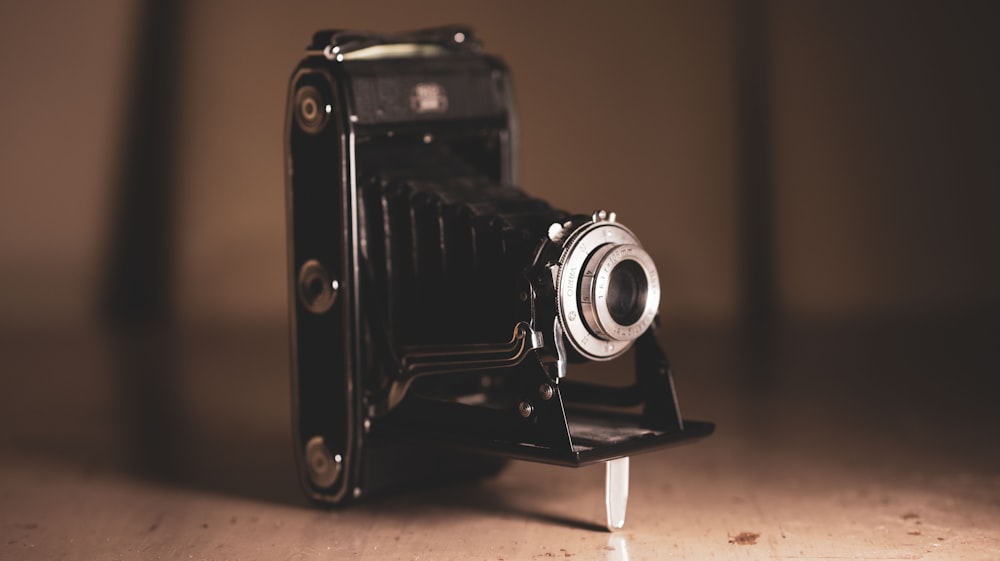 black and silver camera on brown wooden table