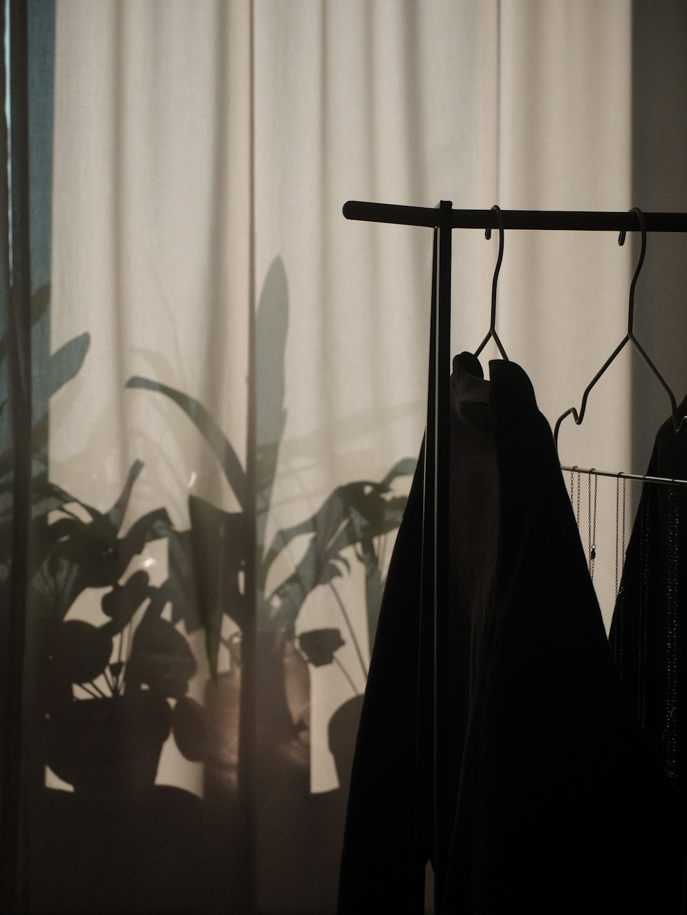 black coat hanged on black clothes hanger