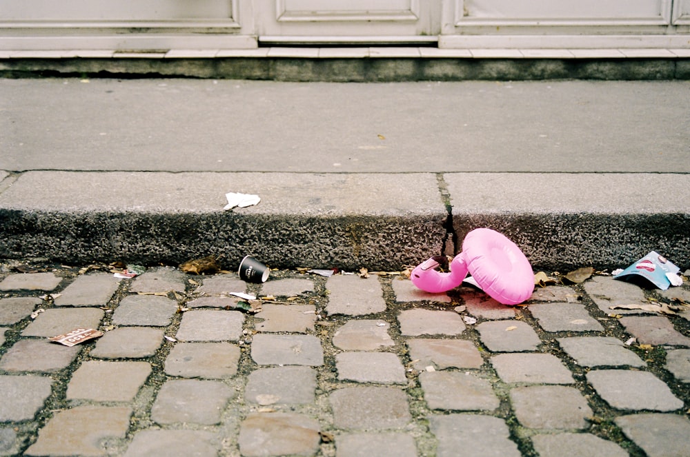 pink balloon on grey concrete pavement