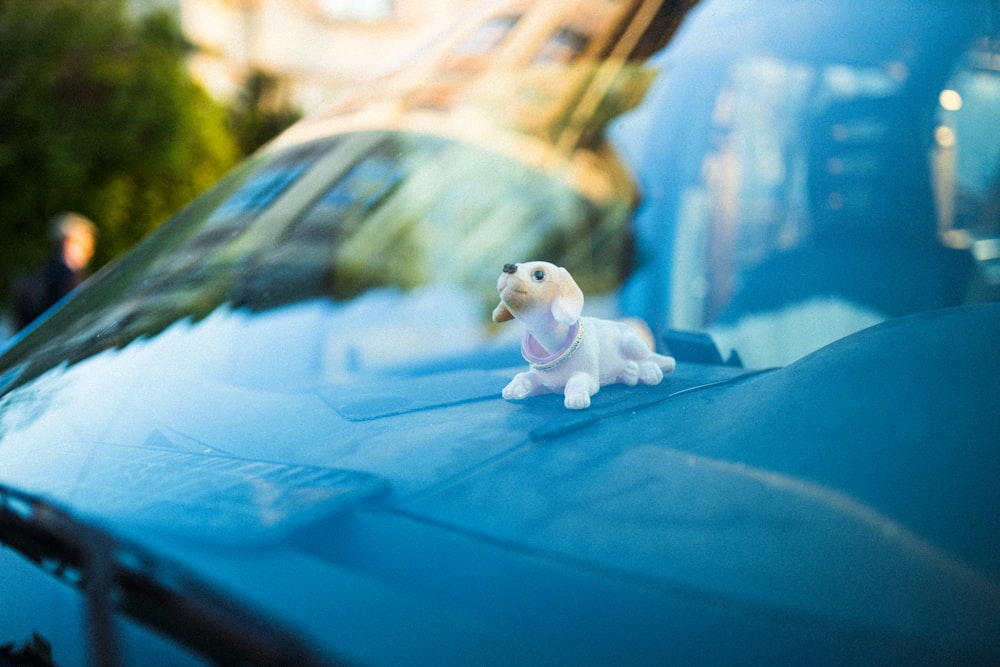 white and brown dog figurine on blue textile