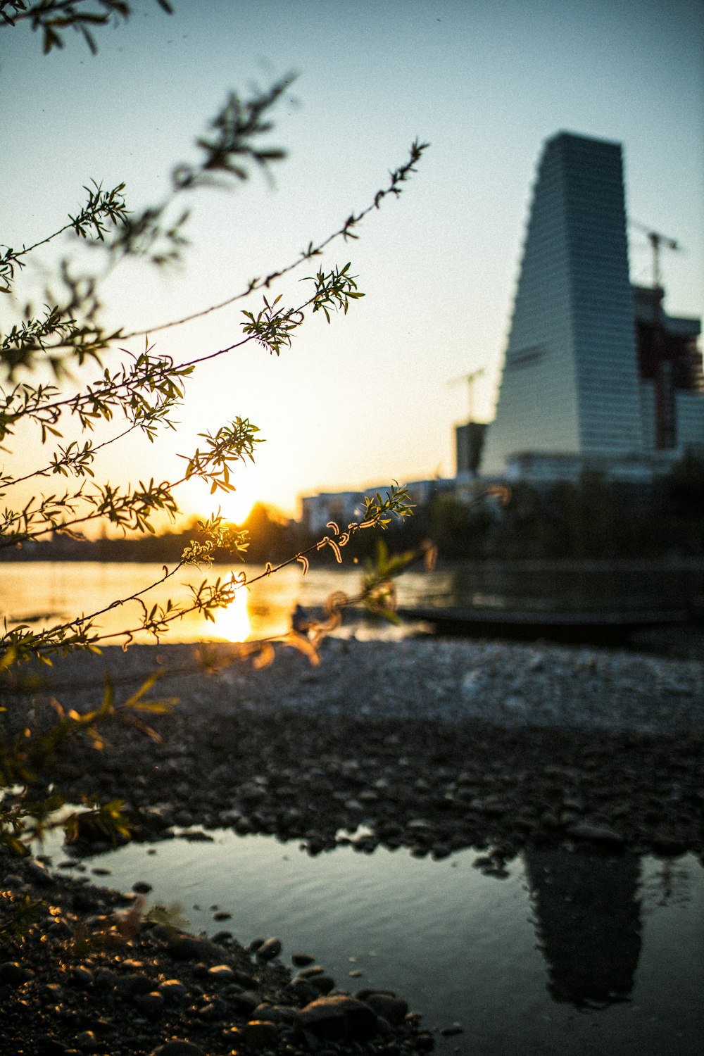 Faro blanco y negro cerca del cuerpo de agua durante la puesta de sol