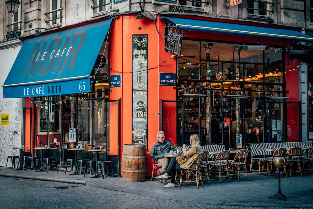 man and woman sitting on chair near store during daytime