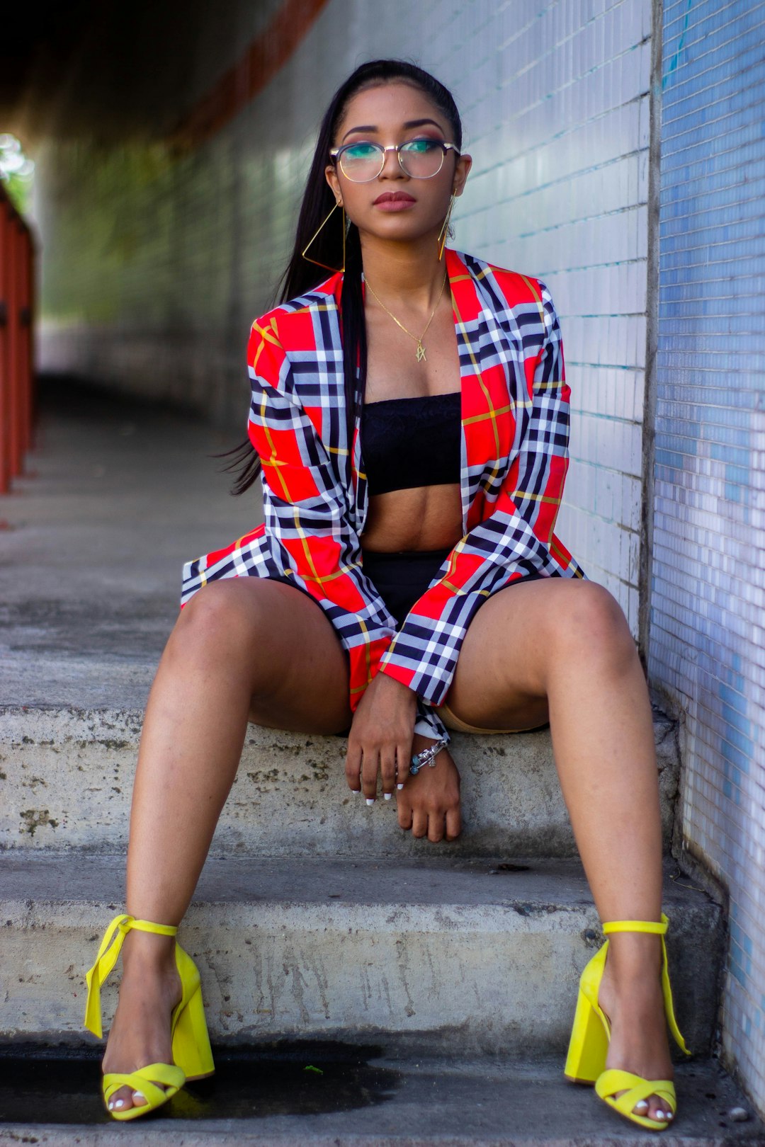 woman in red white and black plaid button up shirt sitting on concrete floor