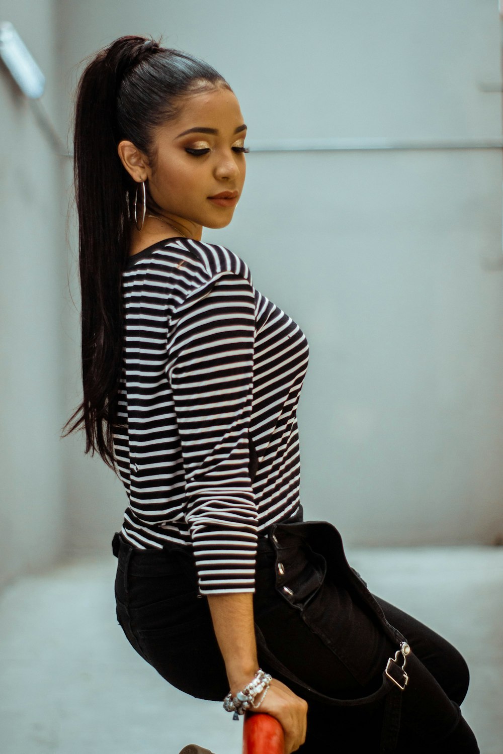 woman in black and white striped long sleeve shirt and black pants sitting on white floor