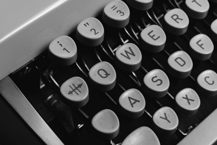 A close-up of a typewriter keyboard in black and white.