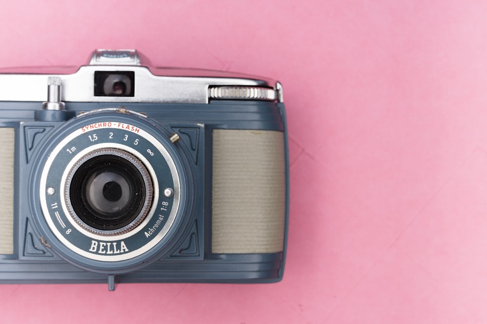 black and silver camera on pink textile