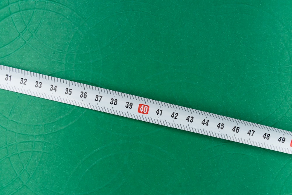 white ruler on green textile