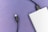 A silver external hard drive partially connected to a black USB cable against a light purple textured background. The focus is on the two USB connectors, one attached to the hard drive and the other detached.