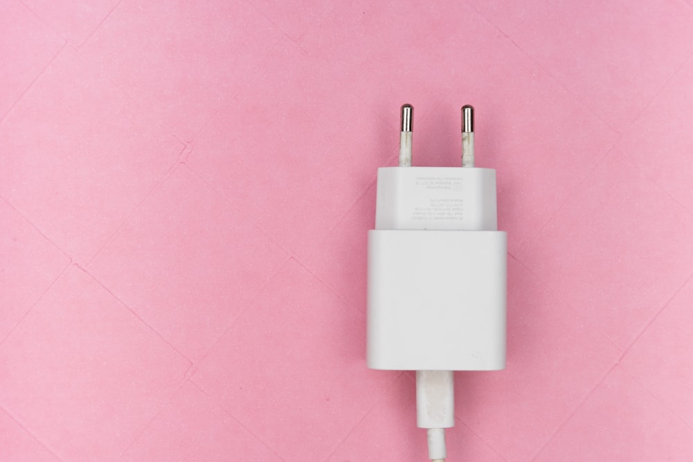 white adapter on pink surface