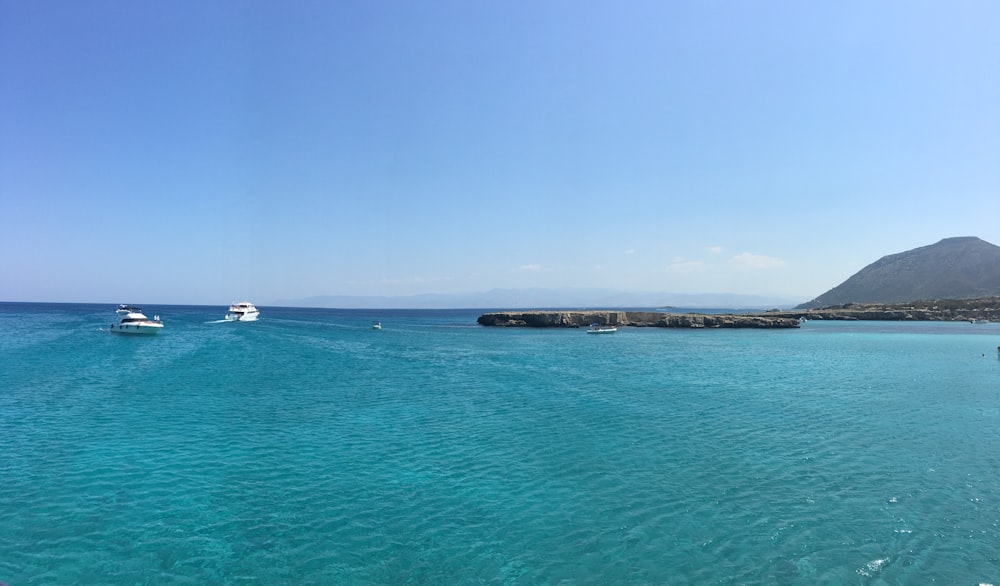 barco branco no mar sob o céu azul durante o dia