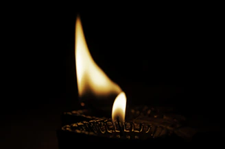 Close-up of a glowing soy wax candle with a wooden wick flickering softly.