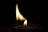 Close-up of a cotton fibre wick burning gently inside a soy wax candle with earthy tones.