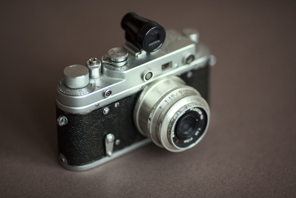 black and silver camera on orange textile