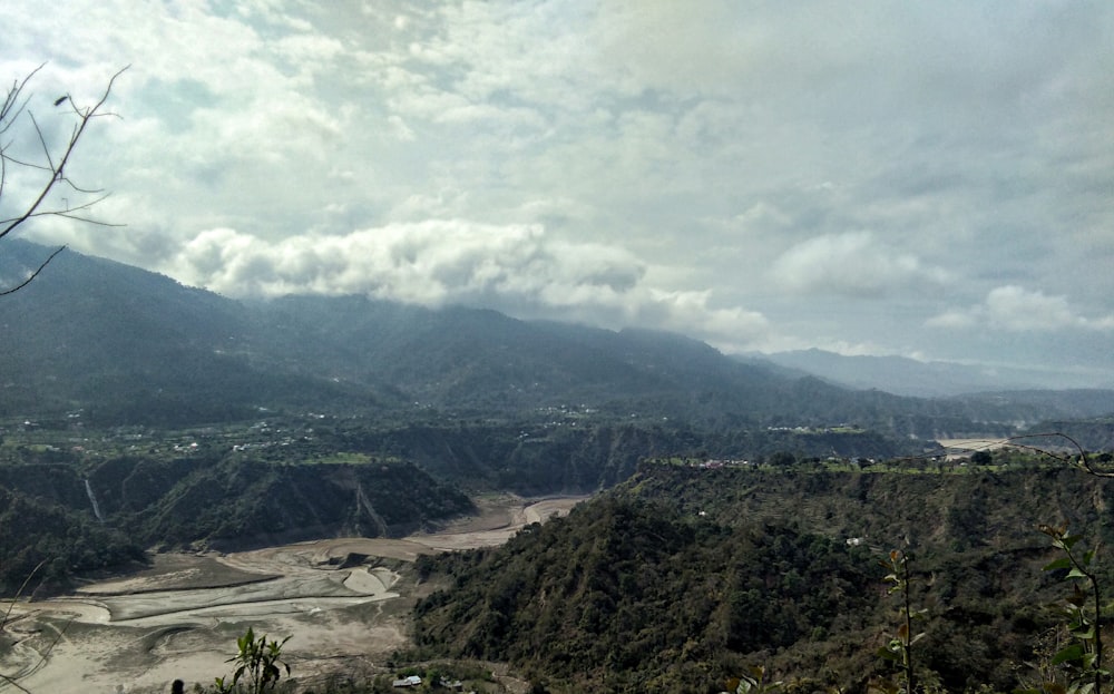 green trees on mountain under white clouds during daytime