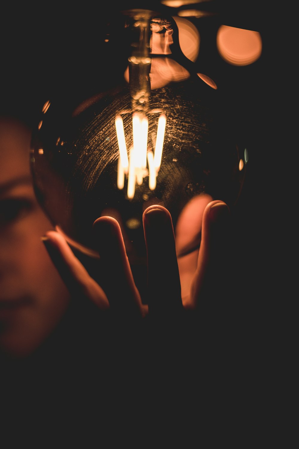 person holding lighted ball with light