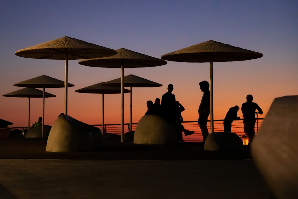 people sitting on brown wooden bench under white and blue sky during daytime