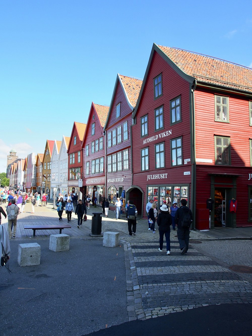 Personas caminando por la calle cerca de un edificio de hormigón rojo durante el día