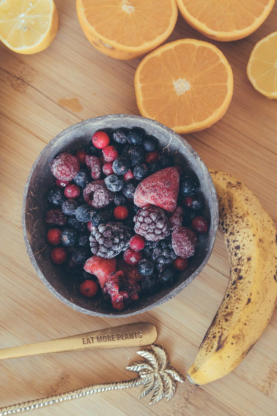 sliced lemon and red berries on brown wooden bowl