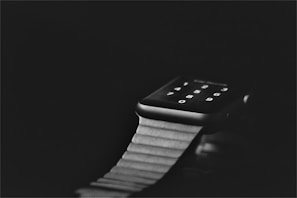 Close-up of a glowing smart watch with a futuristic blue interface on a dark background.