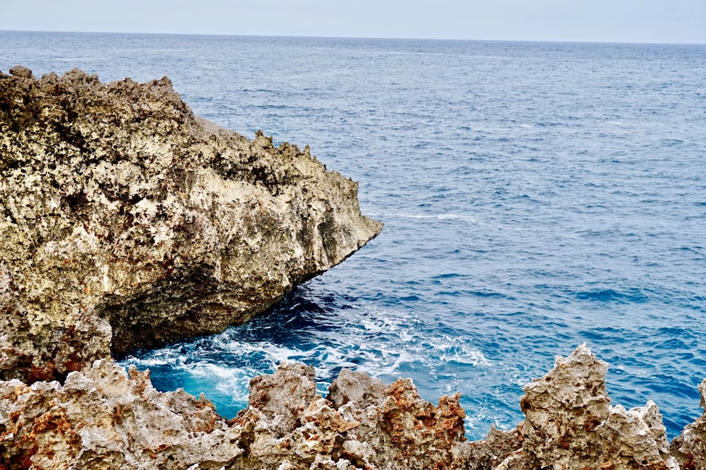brown and gray rock formation on blue sea during daytime