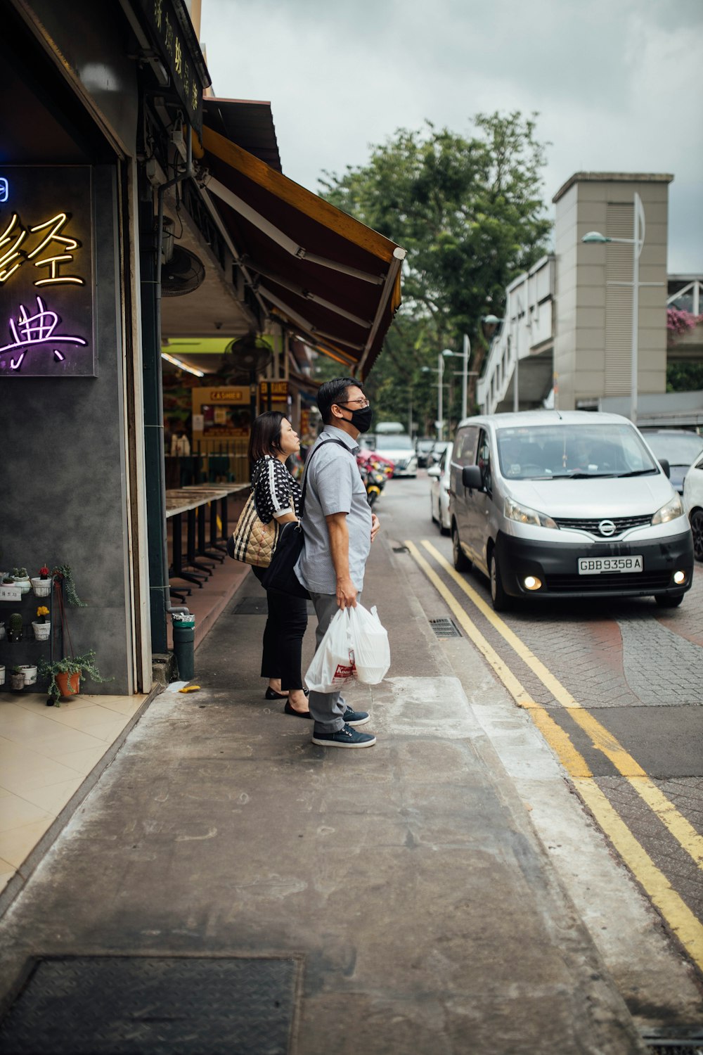 man in white t-shirt and blue denim jeans standing beside woman in white long sleeve