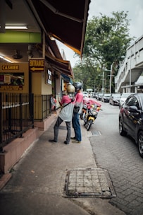 A friendly staff member assisting a customer with two-wheeler insurance paperwork.