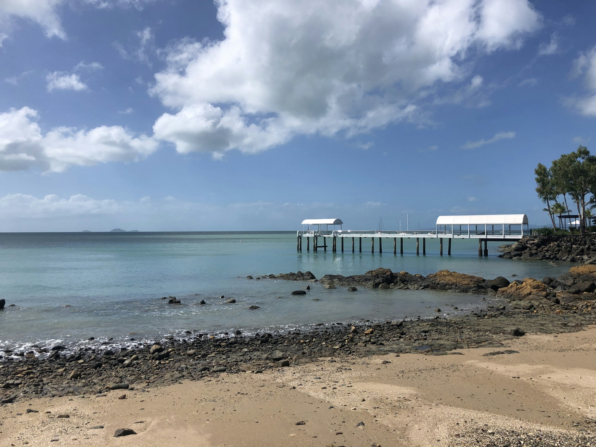 white wooden dock on sea under blue sky during daytime