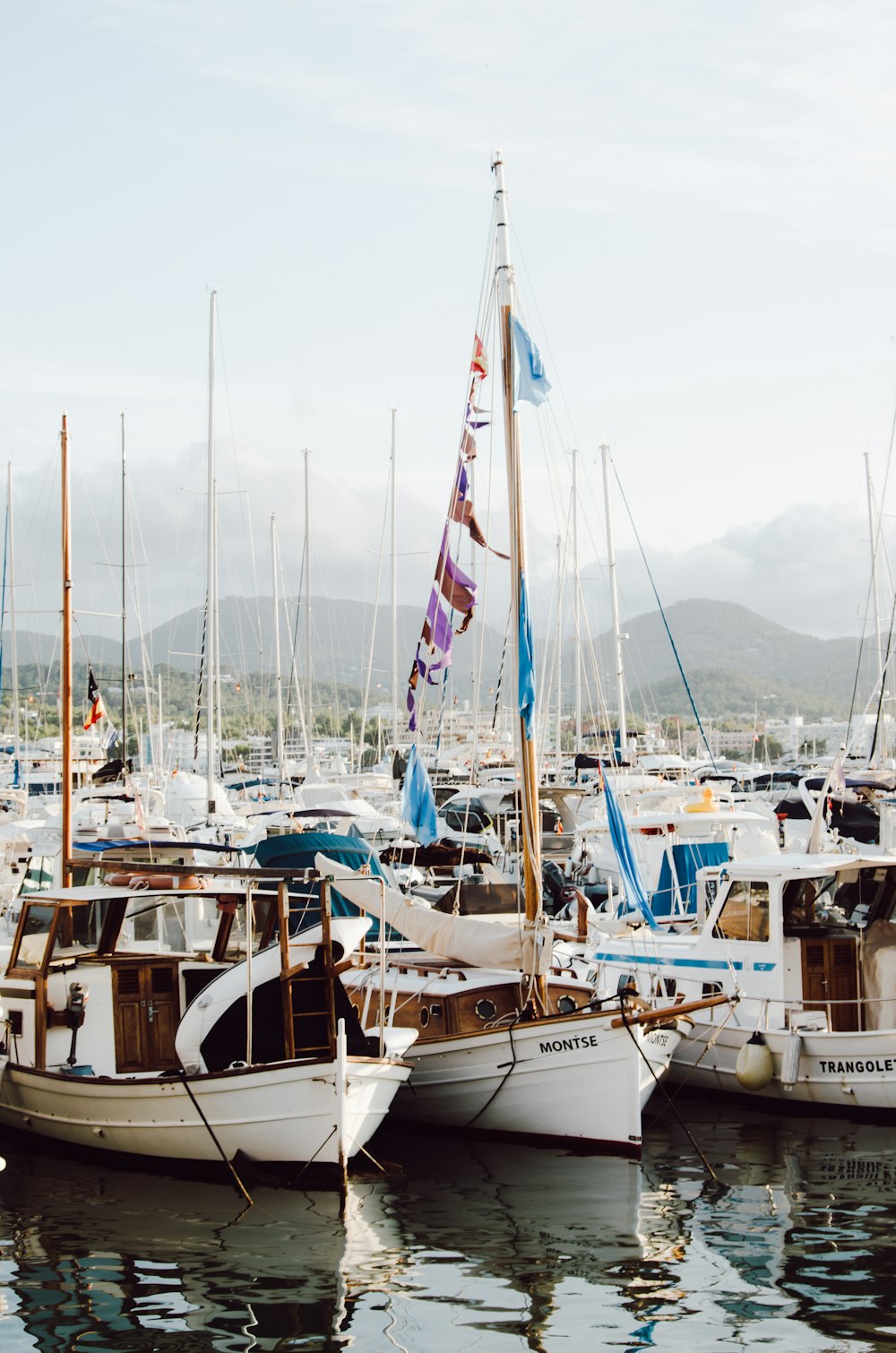 white and blue sail boats on sea dock during daytime