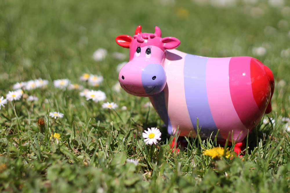 pink and white striped pig toy on green grass