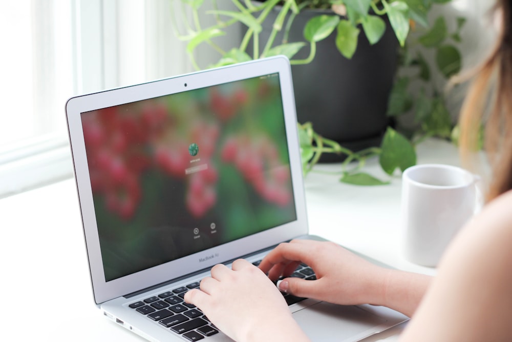 person using macbook air on table