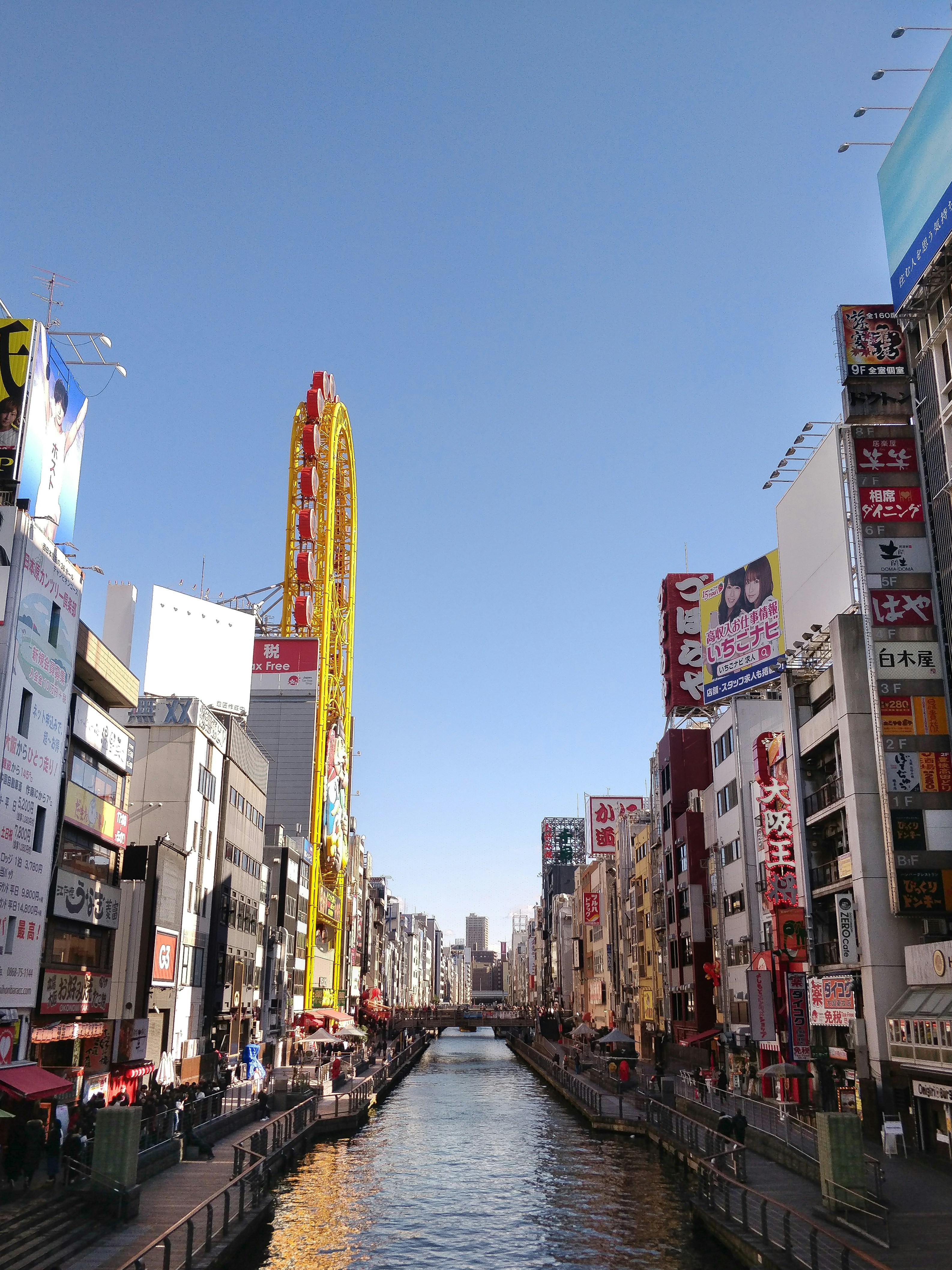 cars on road between high rise buildings during daytime