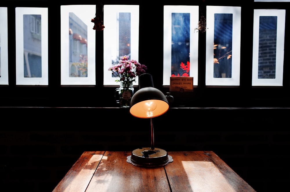 candeeiro de mesa preto e laranja na mesa de madeira marrom