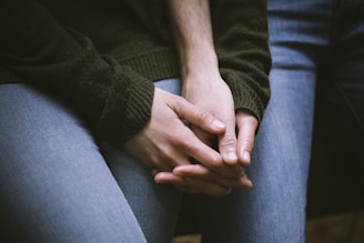 person in black sweater and blue denim jeans
