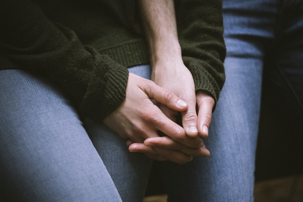 person in black sweater and blue denim jeans