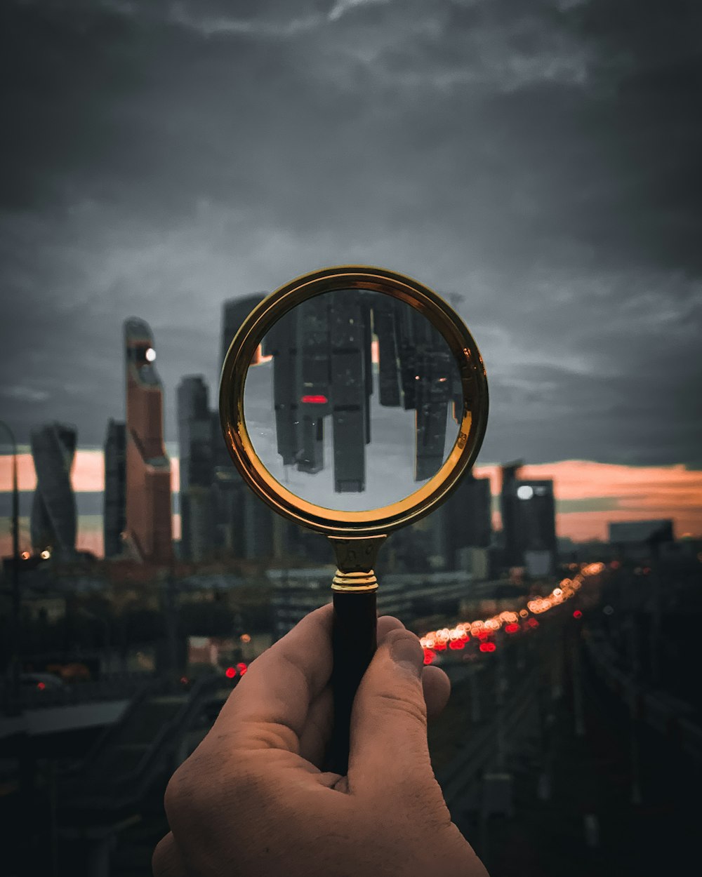 person holding magnifying glass during daytime