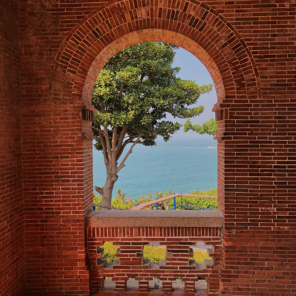 brown brick arch with green tree in the middle