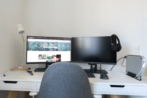 black flat screen computer monitor on white wooden desk