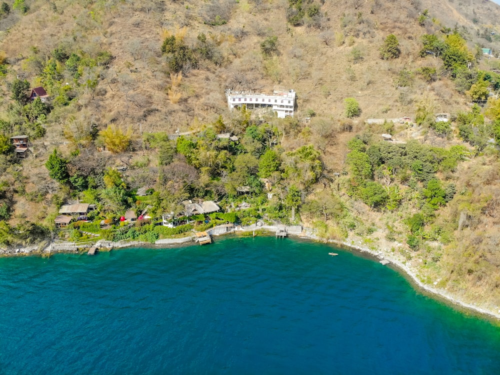 Weißes Gebäude auf grünem Grasfeld am blauen Meer tagsüber