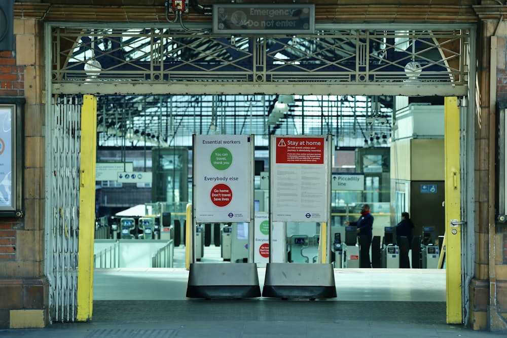 white and red signage on white and yellow train station