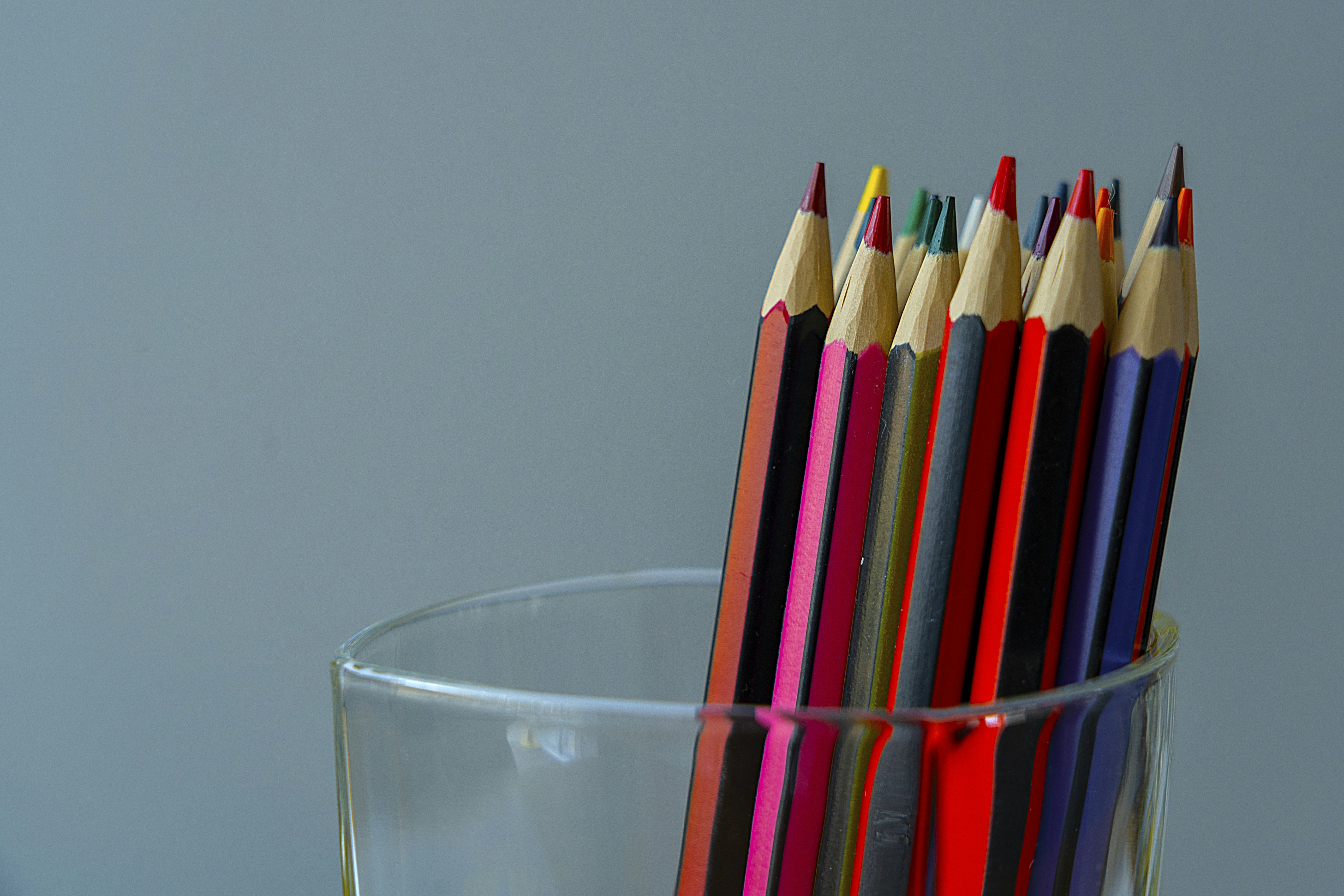 Coloured pencils, upright in a glass holder, ready to colour with.