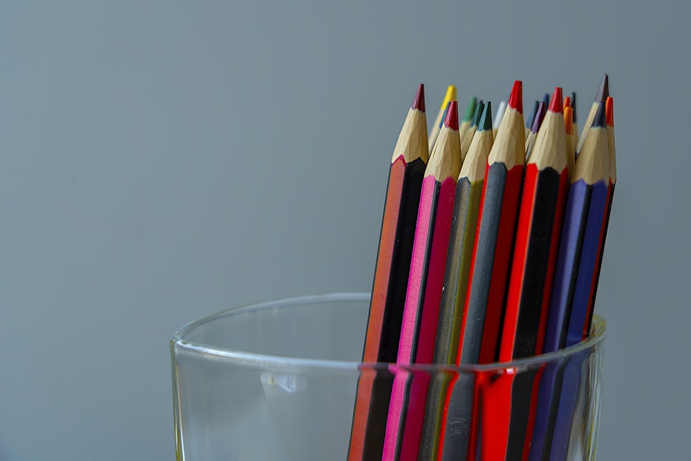 crayons de couleur dans un verre à boire transparent