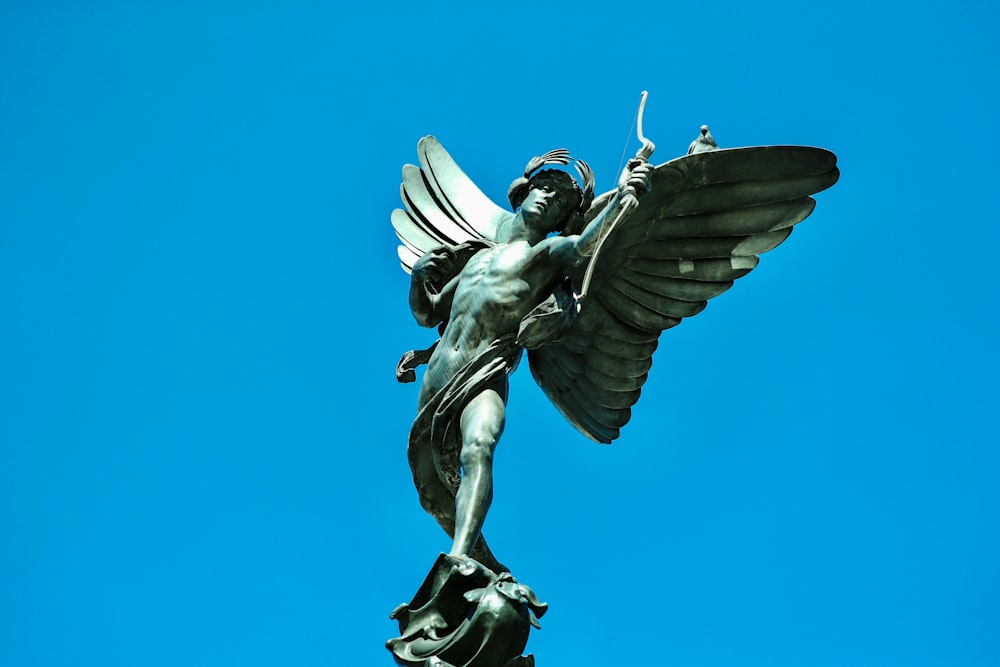 anjo segurando uma estátua do pássaro