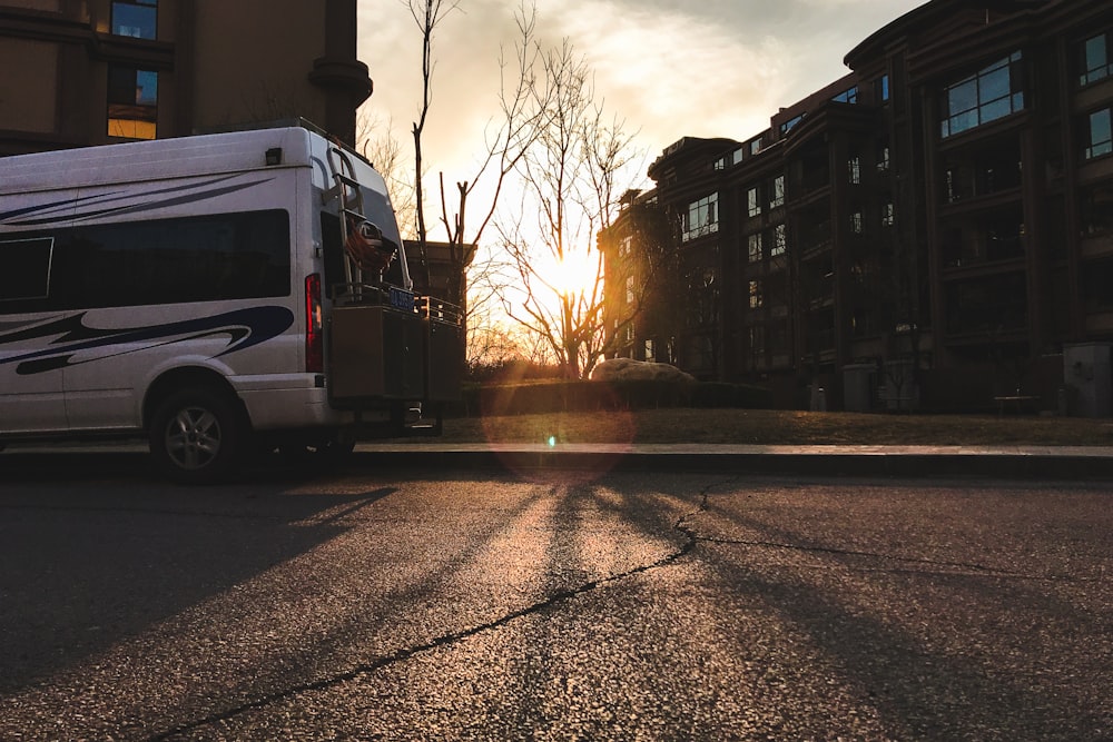 white van parked beside brown building during daytime