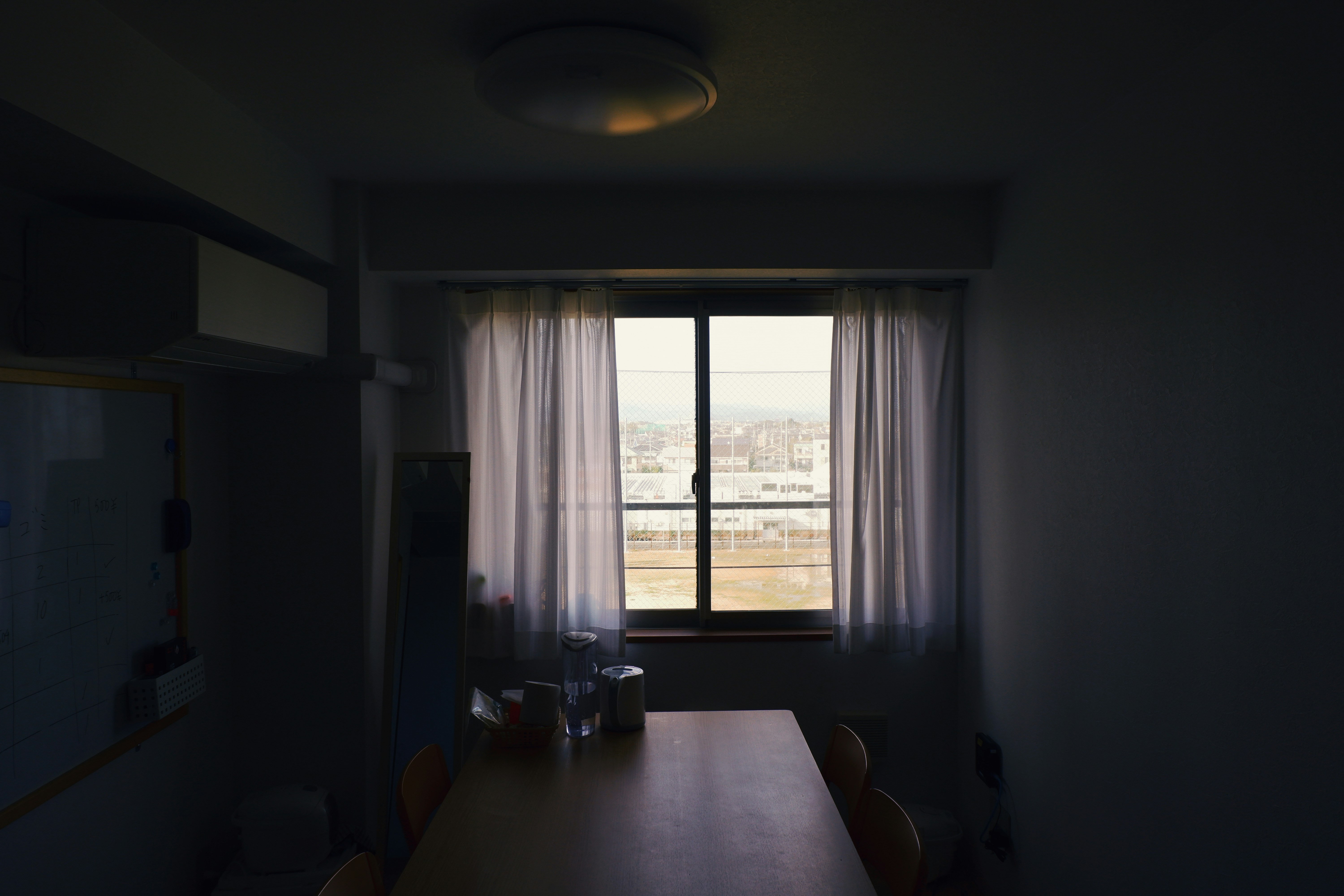 brown wooden table near white window curtain