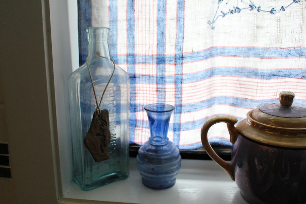 blue glass pitcher beside white ceramic mug