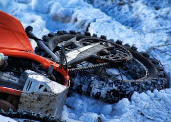 orange and black snow blower on snow covered ground
