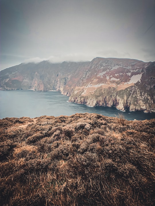 brown and green mountain beside body of water during daytime in Slieve League Ireland